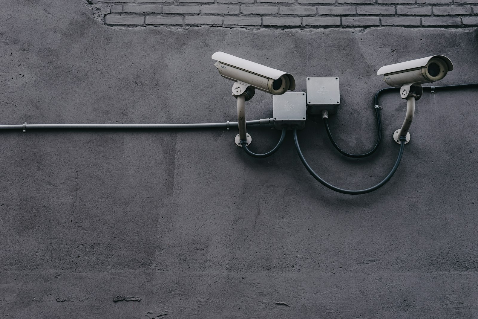 Two surveillance cameras mounted on a building wall